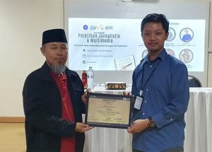 Asnawin Aminuddin (pakai kopiah) menerima sertifikat dari Ketua Panitia Pelatihan Jurnalistik dan Multimedia FKIK Unismuh Makassar, Dokter Dzar Fadli El Furqan, di Aula Gedung FKIK Unismuh Makassar, Minggu, 29 Januari 2023.