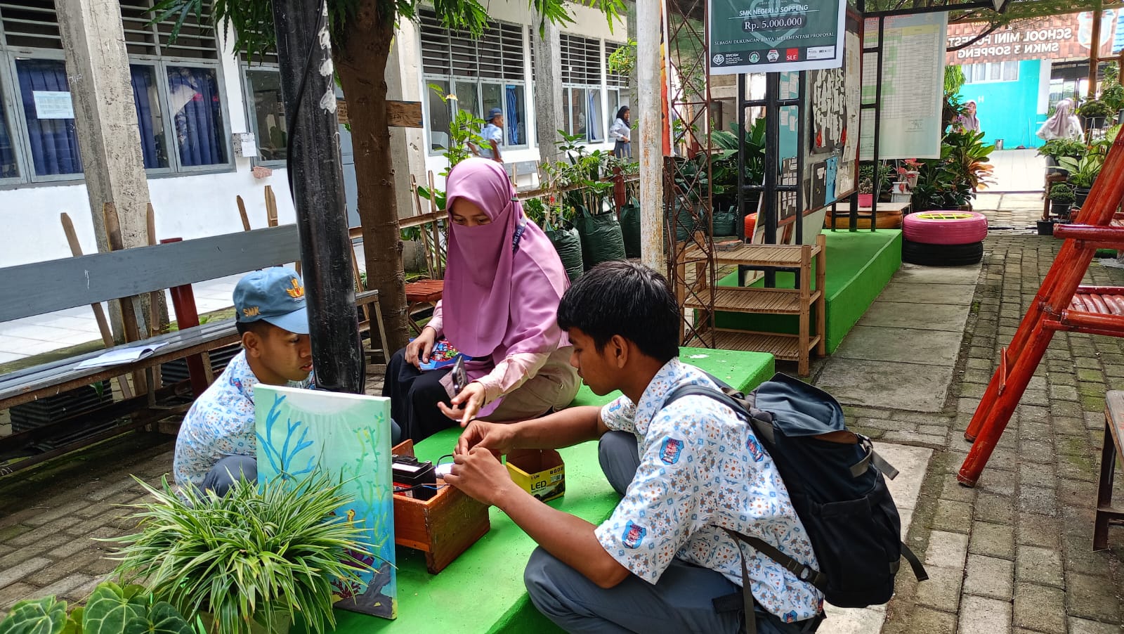 "Kepala SMKN 3 Soppeng, Reni Andriani,S.Pd., M.Pd., dampingi siswa manfaatkan energi matahari jadi listrik."