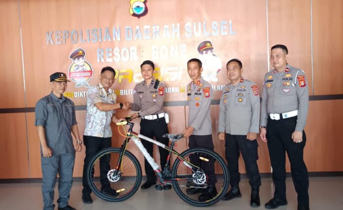 Kepala Kesbangpol Kabupaten Bone, Andi Amran, menyerahkan satu unit sepeda sebagai bentuk apresiasi kepada Bripda Rian Isdal, di Mapolres Bone, Jumat (5/7/2025).