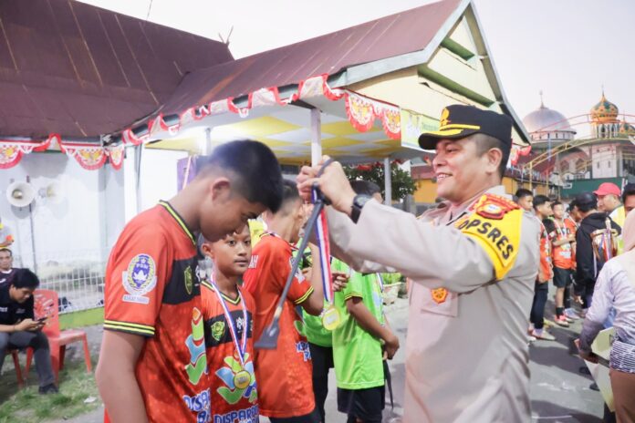 Kapolres Barru, AKBP Ananda Fauzi Harahap, S.I.K., M.H., saat mengalungkan medali kepada para juara pada penutupan Liga Ramang 2025 di Lapangan Palanro. (Dok. Humas Polres Barru