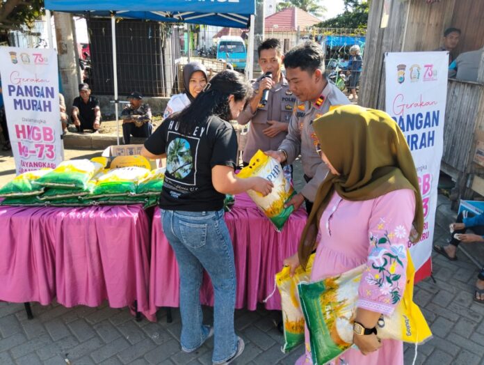 Kapolsek Tanete Rilau Iptu Muhammad Yusran, S.Sos menyerahkan beras Stabilisasi Pasokan dan Harga Pangan (SPHP) kepada warga