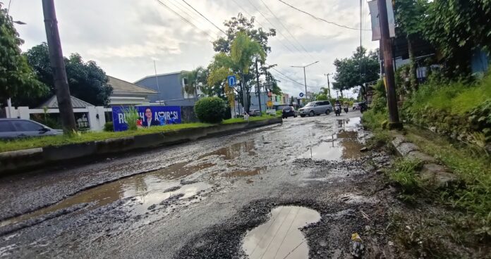 Waspada! Lubang besar di Jalan Jenderal Sudirman, Kelurahan Sumpang Binangae, Barru, tergenang saat hujan dan rawan kecelakaan. Perbaikan hanya tambal sulam, warga minta perbaikan permanen agar aman bagi pengendara! (Doc. Fajar Pendidikan.co.id)