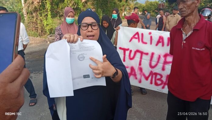Warga menunjukkan tanda tangan yang diduga dimanipulasi saat aksi demonstrasi penolakan tambang sirtu di Desa Lompo Tengah, Kecamatan Tanete Riaja, Kabupaten Barru. (Foto: fajarpendidikan.co.id)